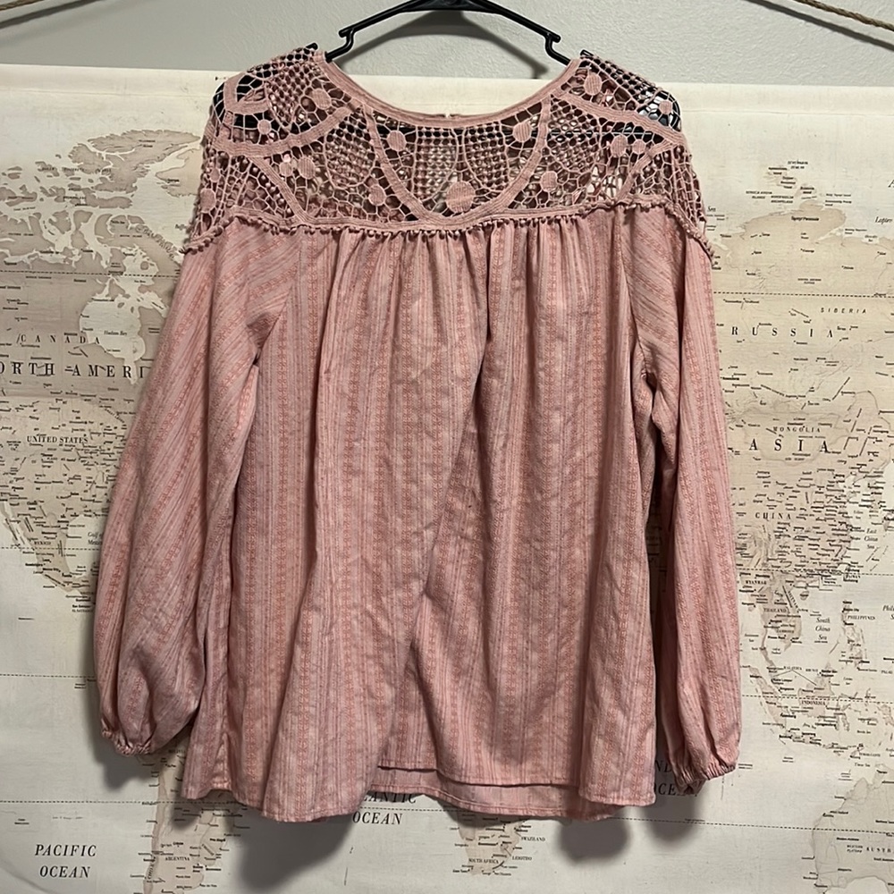 Light fabric long sleeve shirt. Pink in color with lacy detail at the top.